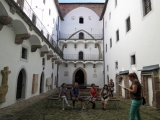 Študenti počúvajú vyučujúcu. Len dvaja výtečníci fajčia za rohom.